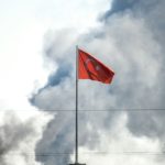 A picture taken in Akcakale at the Turkish border with Syria on October 10, 2019 shows the Turkish flag as smokes rises from the Syrian town of Tal Abyad after a mortar landed in Akcakale. - At least 18 people were injured in shelling on a Turkish border town on October 10, local media said, a day after Turkey launched an operation against Kurdish forces in northern Syria. (Photo by BULENT KILIC / AFP)