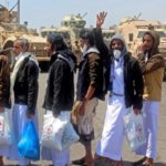 International Red Cross workers and Yemeni officials coordinate as prisoners walk towards a plane used to carry them to the rebel-held capital Sanaa, at an airport in the southern city of Aden, the interim seat of the Yemeni government, on October 16, 2020, as the war-torn country began swapping 1,000 prisoners in a complex operation overseen by the International Committee of the Red Cross. - Over 170 former prisoners of war were freed today on the second day of a landmark exchange between war-torn Yemen's government and Huthi rebels, the International Committee of the Red Cross said. A plane from the southern city of Aden, the interim seat of the Yemeni government, took 101 former prisoners to the rebel-held capital Sanaa, while another aircraft transported 76 detainees in the opposite direction, the ICRC said on Twitter. (Photo by Saleh Al-OBEIDI / AFP)