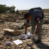 یک کودک دانش‌آموزان فلسطینی در محل ویران‌شده مدرسه خود برگه‌ای از دفتر مشق را از میان ویرانه‌ مدرسه برمی‌دارد.