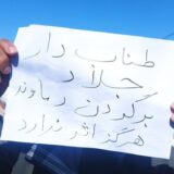 روی کاغذی که معترضی در دست گرفته نوشته شده: «طناب دار جلاد، بر گردن دماوند، هرگز اثر ندارد»