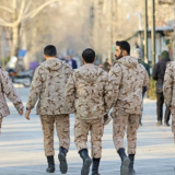 پنج سرباز در حال راه رفتن در ایی شبیه پارک