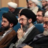 مجتبی در میان دو نفر نشسته و انگشت زیر چانه گذاشته