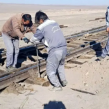 پنج کارگر راه آهن در گرمای روز در حال کارند