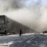 پشت سر یک فلسطینی انبوهی از دود و خاکستر ناشی از حمله اسرائیل به شمال غزه دیده می شود. ۲۴ اکتبر ۲۰۲۴